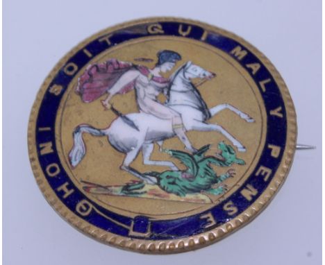 An early 20th century yellow metal and enamel brooch badge of St George slaying a dragon with the motto Ohoni Soit Qui Mal Y 