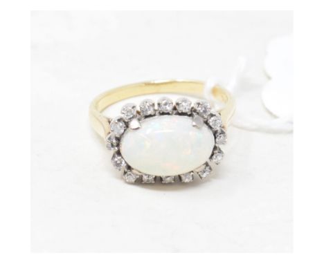 An 18ct gold ring, set an oval opal within a surround of sixteen diamonds 