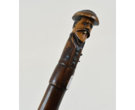A folk art walking cane, the handle in the form of a WWI soldier smoking a cigar, the shaft dated 1919, 91 cm 