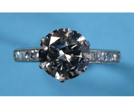 An 18ct white gold ring, set a solitaire diamond of approx. 2.4ct in a mount of eight diamonds, approx. ring size O½ See illu