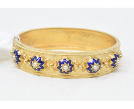 A late Victorian bangle, with blue enamel decoration and set seed pearls 