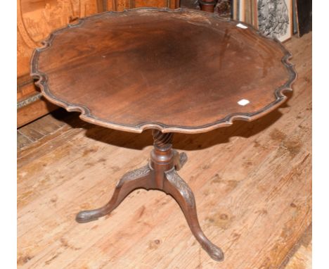 A mahogany tripod table, with a piecrust top, a fluted and reeded vase turned column and leaf carved feet, 82 cm diameter 