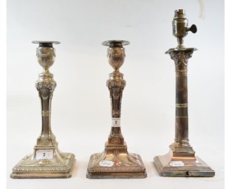 A pair of silver plated candlesticks, with embossed urn and swag decoration, the stems decorated rams' heads, 30.5 cm high, a