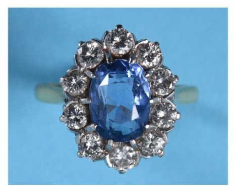 An 18ct gold ring, set an oval cushion cut Ceylon sapphire of approx. 2.6ct within a surround of ten brilliant cut diamonds, 