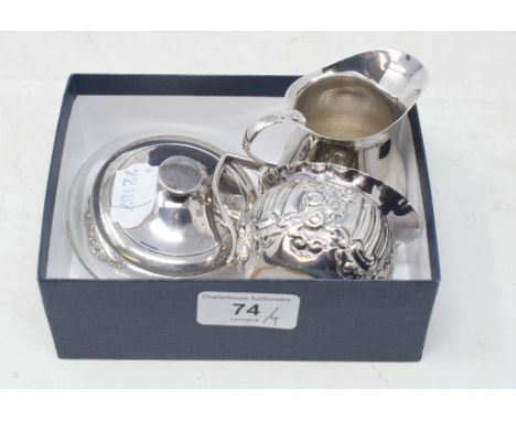 A silver cream jug, with embossed decoration, London 1896, another silver cream jug, a silver decanter label, and a silver mo
