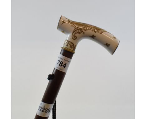 A walking stick, with a Meissen style porcelain handle, decorated a lady within a gilt panel 