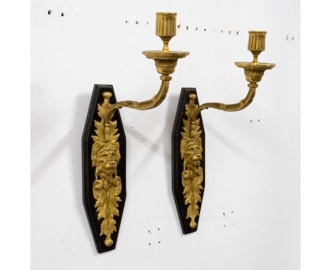 A PAIR OF GILT AND PATINATED BRONZE LION’S MASK WALL APPLIQUÉS (2)With leaf clasped branches, 42 cm high