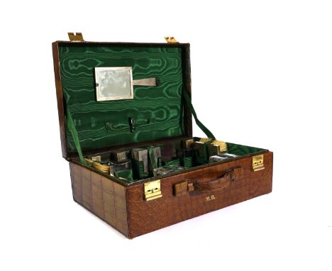 A GEORGE VI SILVER MOUNTED GLASS DRESSING SET IN A FITTED CROCODILE LEATHER SUITCASEBy Asprey &amp; Co Ltd, Circa 1940sCompri
