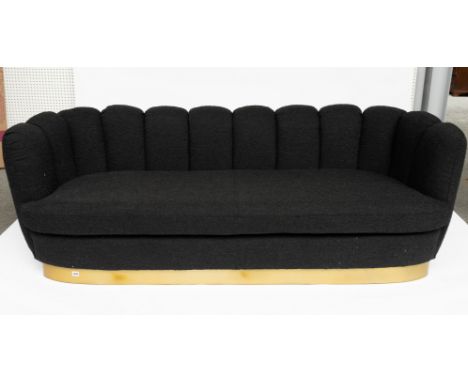 A BLACK UPHOLSTERED SHELL BACK SOFA ON GOLD PLINTH BASE215cm wide; 75cm high
