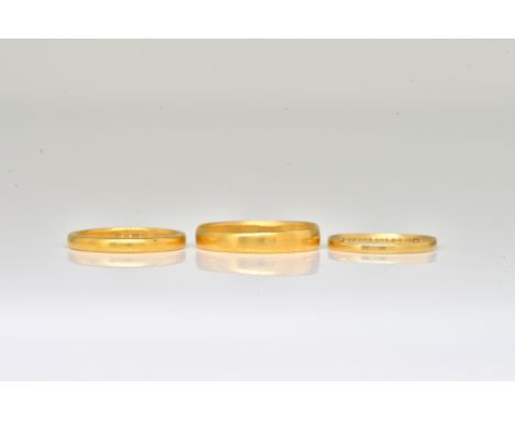 THREE GOLD WEDDING RINGS (3)Comprising; a 22ct gold wedding ring, Birmingham 1914, inscribed with date, 18th July 1923, ring 