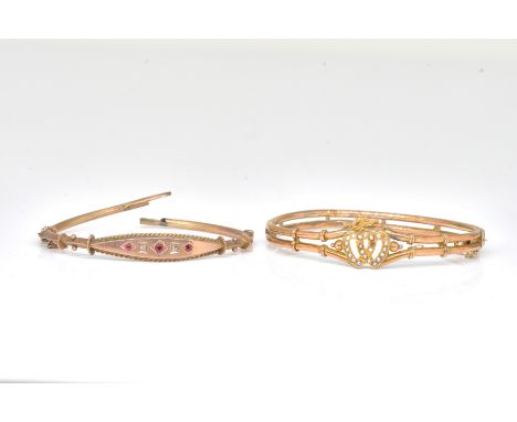 TWO GOLD AND GEM SET BANGLES (2)Comprising; a gold and seed pearl set oval hinged bangle, the front with two entwined hearts 