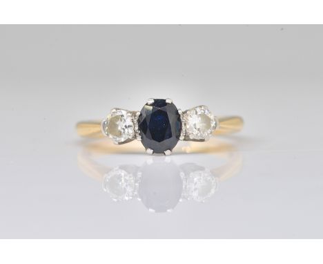 A GOLD AND PLATINUM, SAPPHIRE AND DIAMOND THREE STONE RINGClaw set with the oval cut sapphire at the centre, between two circ