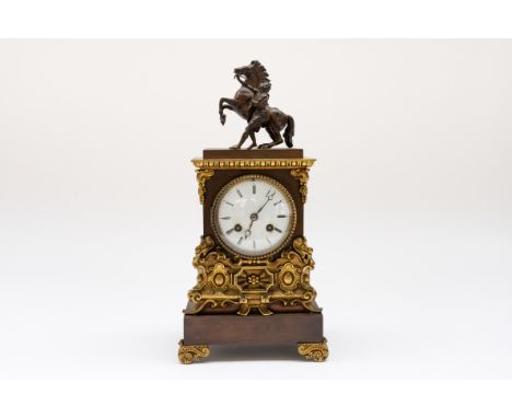 A FRENCH GILT AND PATINATED MANTEL CLOCKLate 19th CenturySurmounted by an equestrian model of the Marley horse, after Coustou