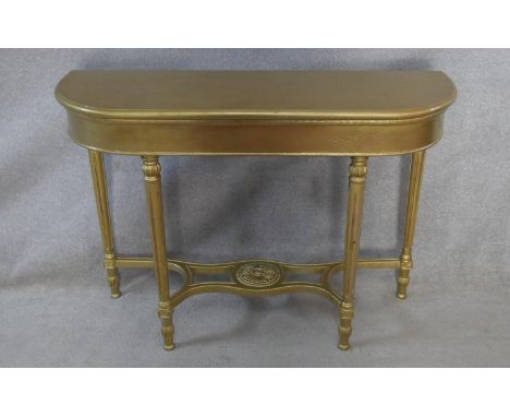 A 19th century style gilt console table on tapering fluted supports united by scrolling under tier. H.82 W.115 D.37.5cm 