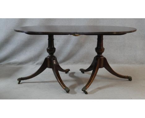 A Georgian style mahogany D end dining table with extra leaf on twin swept tripod pedestal supports. H.74.5 L.207 W.99cm (Wit