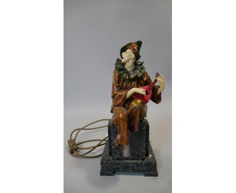 An Art Deco style resin court jester playing the mandolin light, he is sitting on a stepped marble base. Colourful accents to