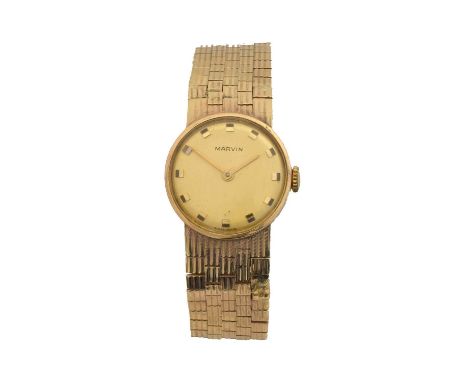A 1970s 9ct gold Marvin manual wind wristwatch. The signed gold tone dial with dot markers, signed cal 320A 17 jewel manual w