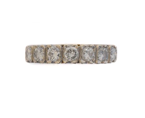 An 18ct gold diamond seven stone ring. The brilliant cut diamond line within shared claw settings, estimated total diamond we