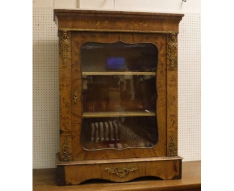 A Victorian walnut and marquetry inlaid side cabinet, the single glazed door of shaped form enclosing a red velvet lined inte