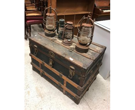 A vintage trunk and four hurricane lamps