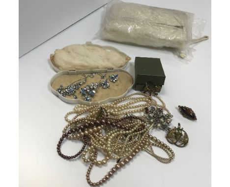 A collection of costume jewellery to include simulated pearl necklaces together with a white rabbit fur muff/purse, a collect