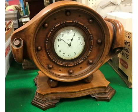 An early 20th Century JW Benson London mantel clock, housed in a carved wooden aeroplane propellor mount, set on a wooden bas