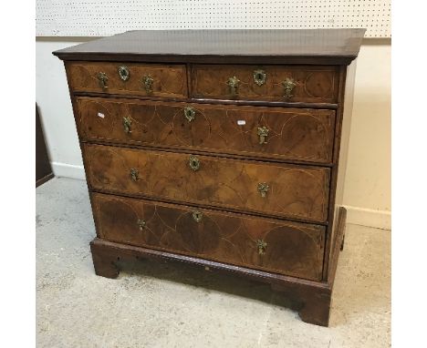 An early 18th Century walnut chest, the quartered and cross banded top with moulded edge over two short and three long gradua
