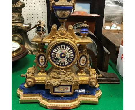 A 19th Century gilt spelter mantel clock with enamelled dial set with Roman numerals, raised on a giltwood base, the clock me