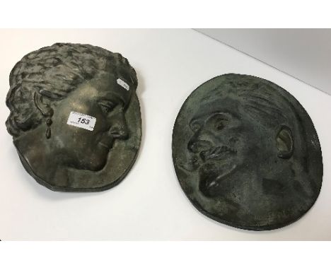 A pair of bronze plaques depicting a woman with ear-ring and man with moustache by Alice Fagny-Sapet 26.5 cm in length and 27