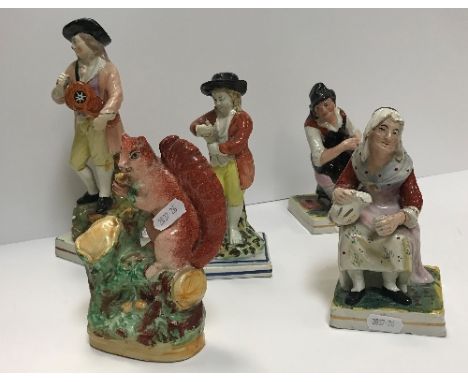 An early 19th Century Pearl ware pottery figure of a hurdygurdy player (circa 1810-20), 23 cm high, another early 19th Centur