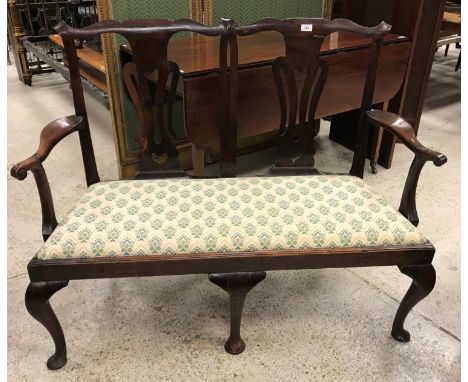 An 18th Century Chippendale style walnut double seat with pierced vase shaped back splats and shaped arms above a drop-in sea