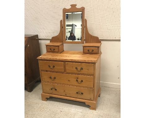 A pitch pine dressing chest in the Victorian manner with mirrored super structure over two short and two long drawers on brac