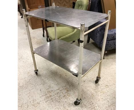 A vintage two tier medical trolley on wheels, the tubular white structure with label inscribed "Chas. F. Thackeray Limited Le