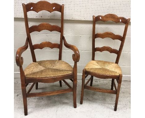 A set of eight French stained beech ladder back rush seat dining chairs in the 19th Century manner (6 plus 2 carvers), 112 cm
