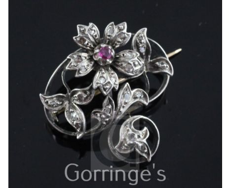 A late 19th century French 18ct gold and silver, ruby and rose cut diamond brooch, of open work scrolling design with flowerh