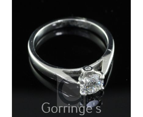 A platinum and single stone diamond ring, with two small diamonds in the setting below, the central round brilliant cut stone