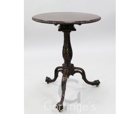 A fine Chippendale period mahogany tea table, the circular top with ribbon and foliate paterae carved rim, on birdcage with p