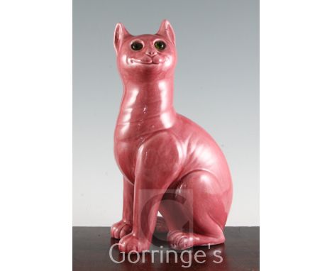 After Louis Wain. A Weymss pink glazed model of a seated cat, with green glass insert eyes, impressed marks, Weymss R & HS, 3
