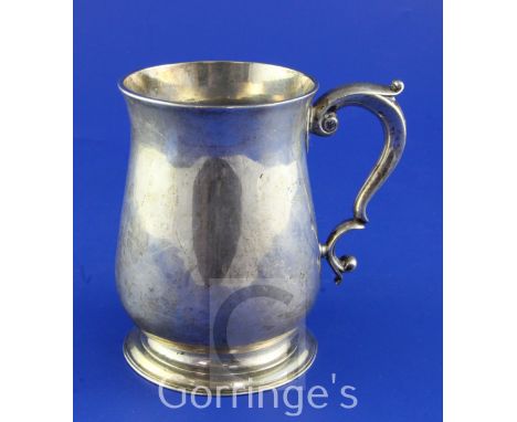 A George II silver baluster mug, with leaf capped scroll handle, maker's mark rubbed, London, 1750, 5in, 11 oz.