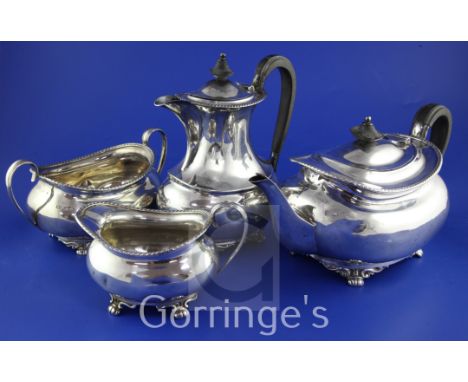 An Edwardian four piece silver tea set, of oval form, comprising teapot, cream, sugar and hot water pot, with gadrooned borde