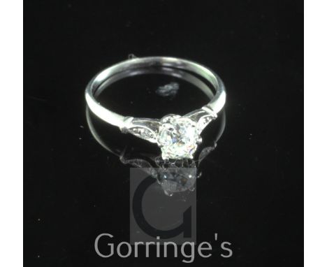 A platinum and single stone diamond ring, with diamond set shoulders, the central cushion cut stone weighing approximately 0.