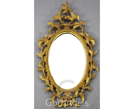 A Chippendale style giltwood wall mirror, with oval plate and foliate surround, W.1ft 5in. H.2ft 6in.