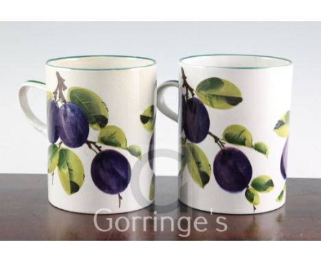 A pair of Wemyss plum pattern mugs, early 20th century, inscribed in green enamel Wemyss T.Goode & Co, 14.5cm, faultes