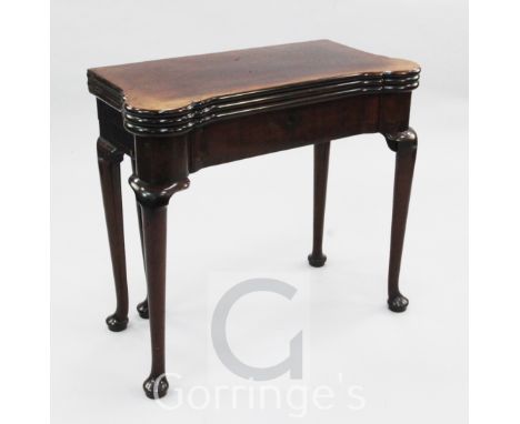 A George II mahogany combined tea, card and games table, with eared triple folding top opening to reveal baize lined card tab