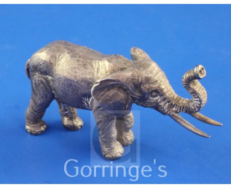 A 1980's silver miniature free standing model of an Indian elephant by John Silvant & Margurite Jones, with raised trunk, Lon