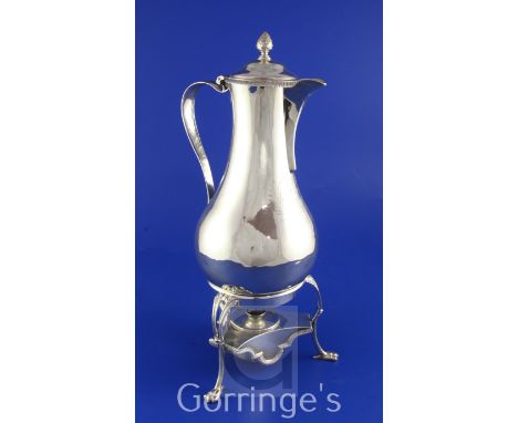 A George III silver hot water jug on tripod stand with burner, of baluster form, with engraved armorials and pineapple finial