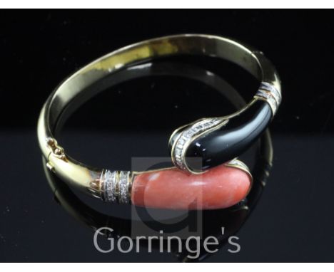 A 14ct gold, coral, black onyx and diamond hinged bangle, the serpent head shaped terminals set with round brilliant cut diam