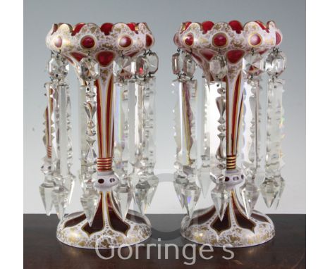 A pair of Bohemian ruby and white overlaid glass table lustres, late 19th century, with arched and oval cut panels, highlight