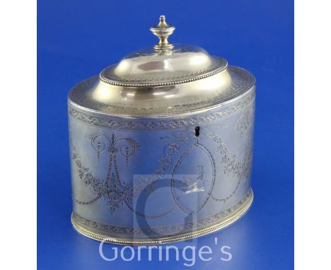 A George III bright cut engraved silver oval tea caddy by Hester Bateman, with engraved armorial and decorated with floral sw