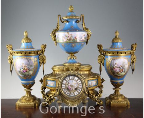 A 19th century French ormolu and jewelled Sevres style porcelain clock garniture, the mantel clock with urn surmount and flor